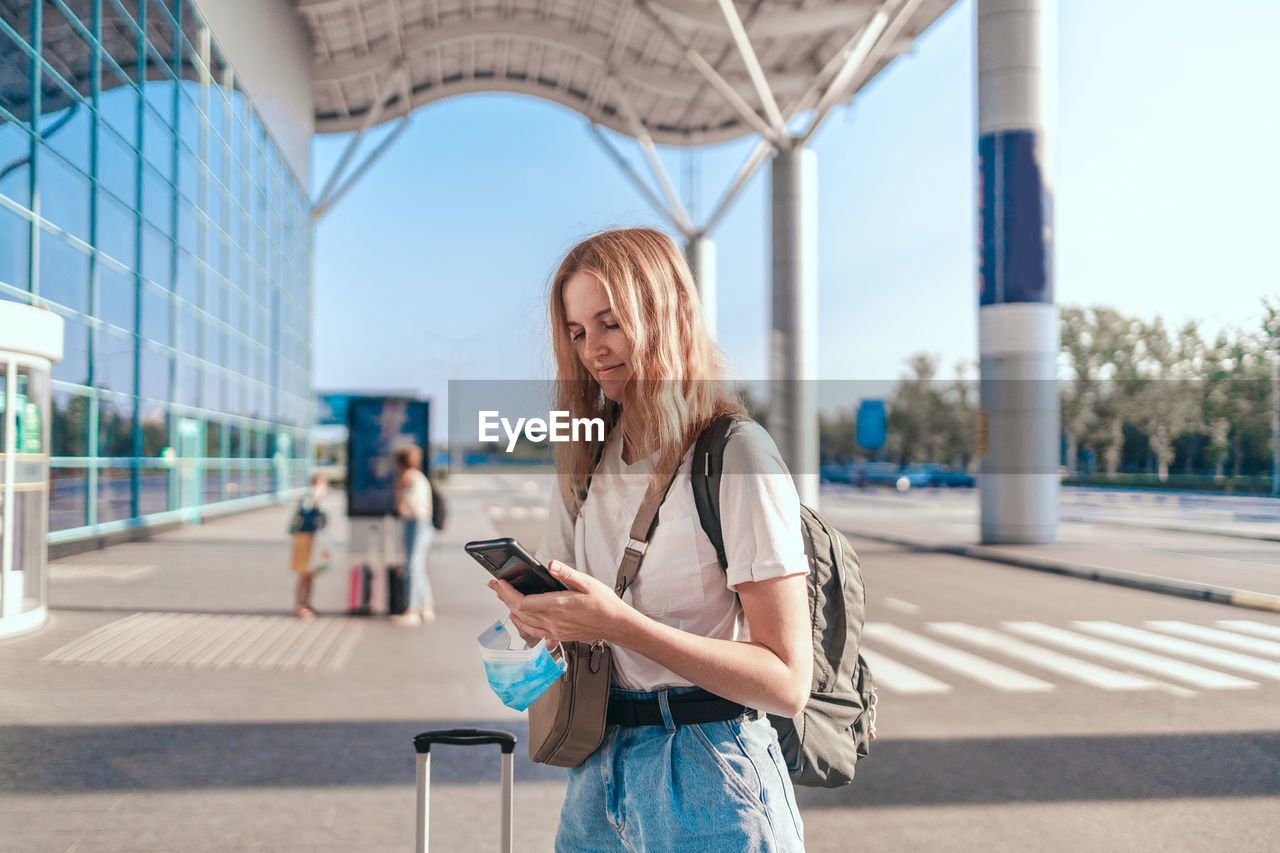 Smiling woman using mobile phone outdoors