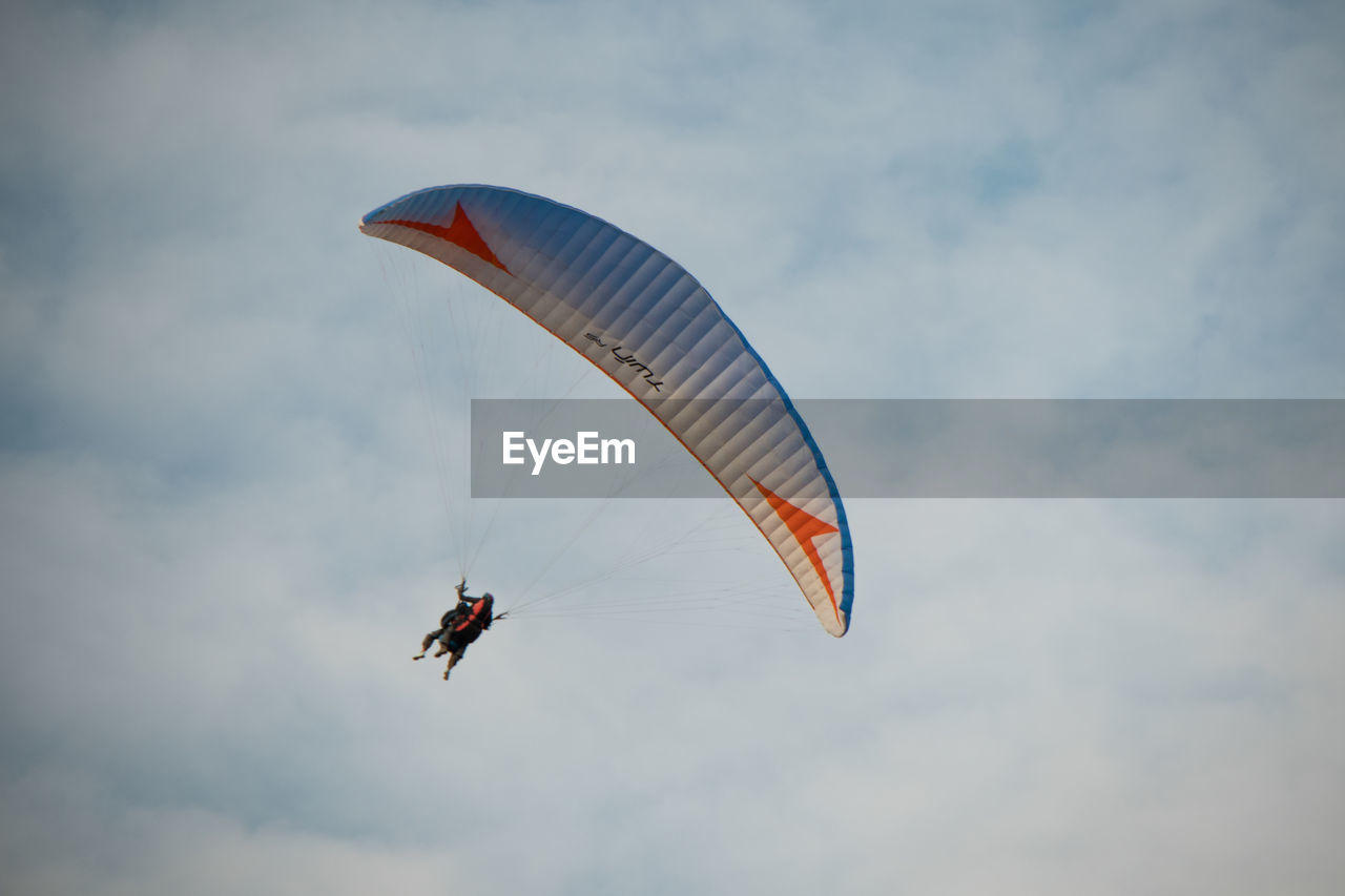 LOW ANGLE VIEW OF PERSON PARAGLIDING IN SKY
