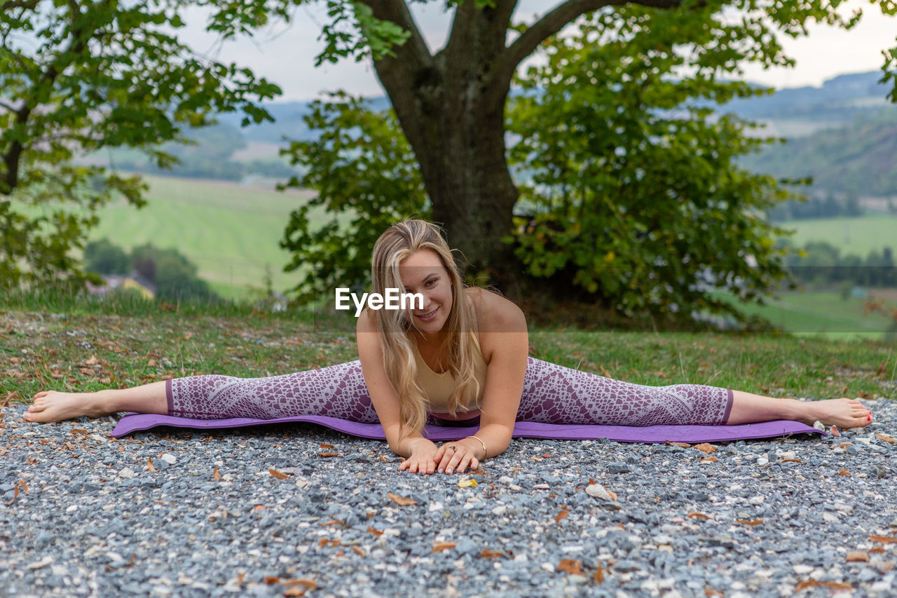 women, adult, one person, tree, plant, relaxation, lifestyles, exercising, nature, wellbeing, sitting, yoga, clothing, leisure activity, person, young adult, full length, zen-like, blond hair, meditating, stretching, physical fitness, human face, long hair, arm, hairstyle, sports, human leg, female, smiling, lying down, tranquility, day, outdoors, spirituality, limb, portrait, happiness, beauty in nature, tranquil scene, emotion, summer, vitality, front view, flexibility, martial arts, park, holiday, land, enjoyment, human hair, eyes closed, sports clothing, human eye, balance