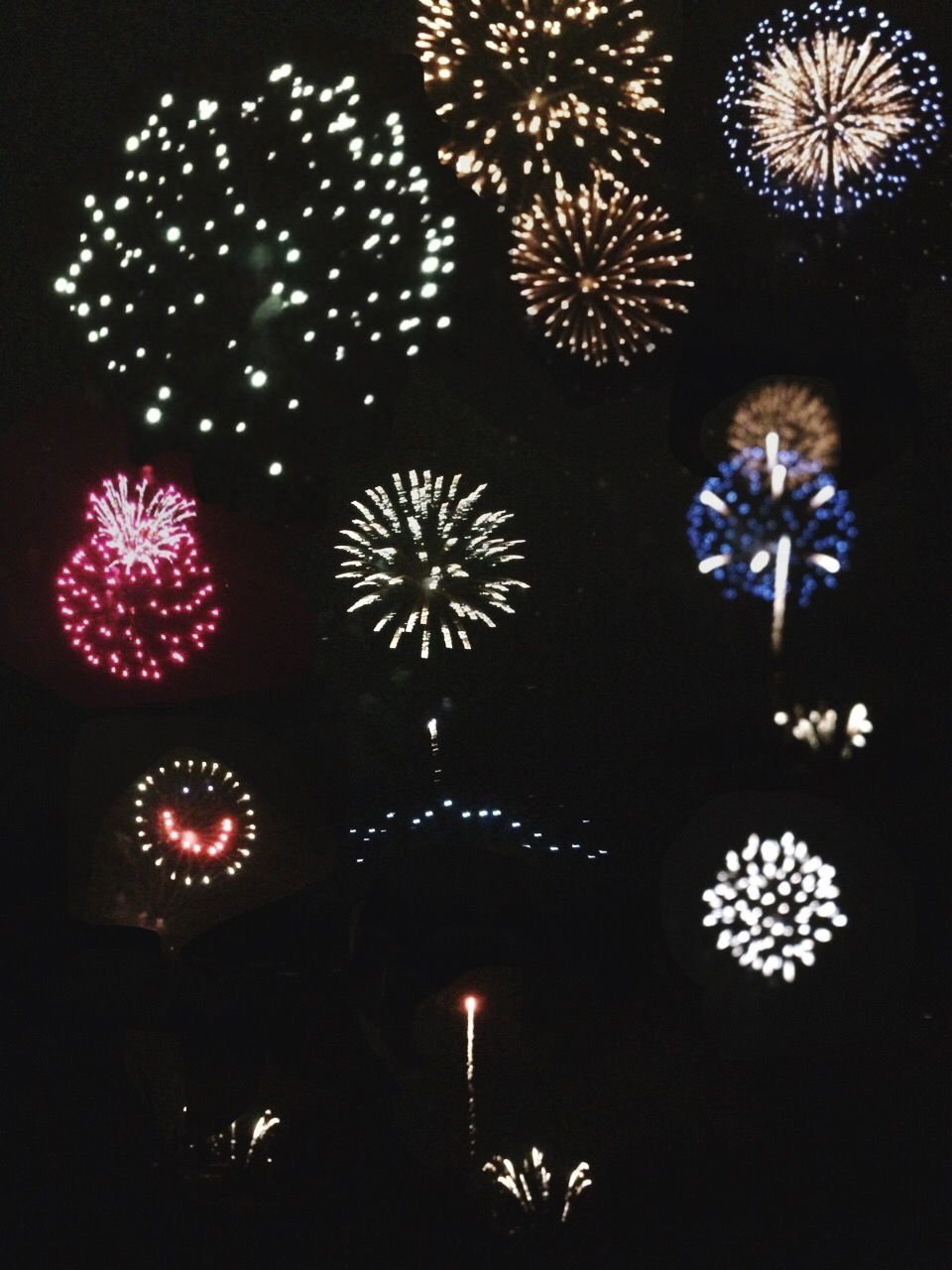 LOW ANGLE VIEW OF ILLUMINATED FIREWORK DISPLAY AT NIGHT