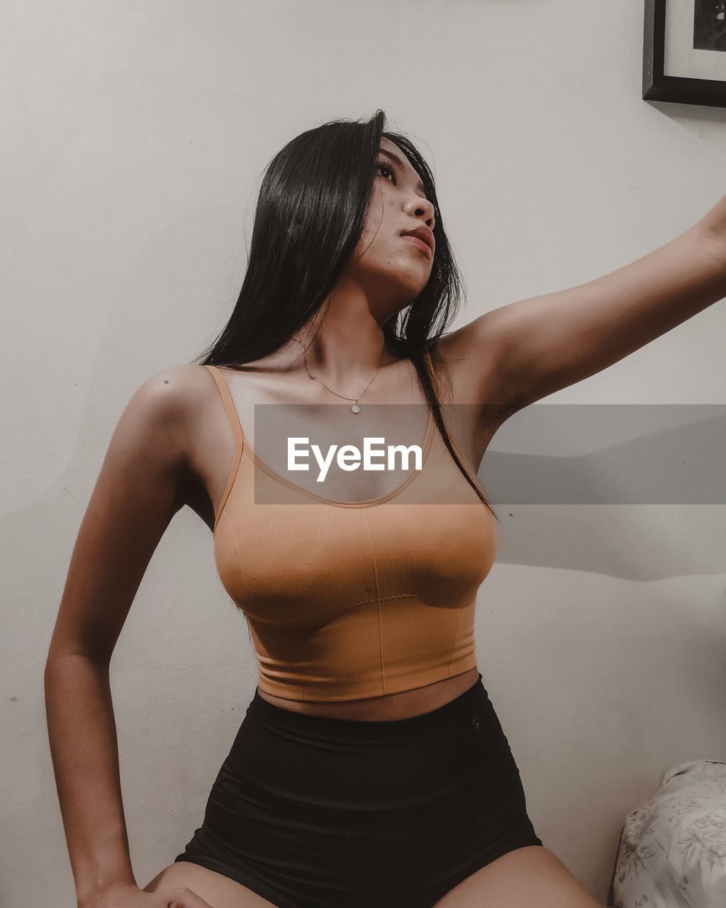 one person, adult, women, limb, human leg, indoors, young adult, clothing, undergarment, lifestyles, photo shoot, exercising, trunk, hairstyle, black hair, long hair, arm, three quarter length, wellbeing, portrait, person, female, sports clothing, brassiere, sports, strength, standing, human limb, muscular build, black, looking, relaxation, brown hair, waist up, physical fitness, studio shot, fashion