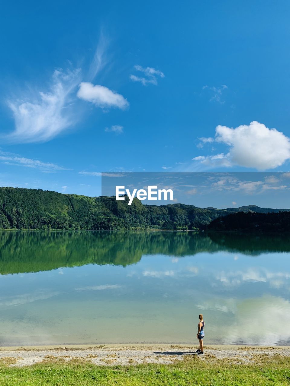 Rear view of woman walking on field against sky