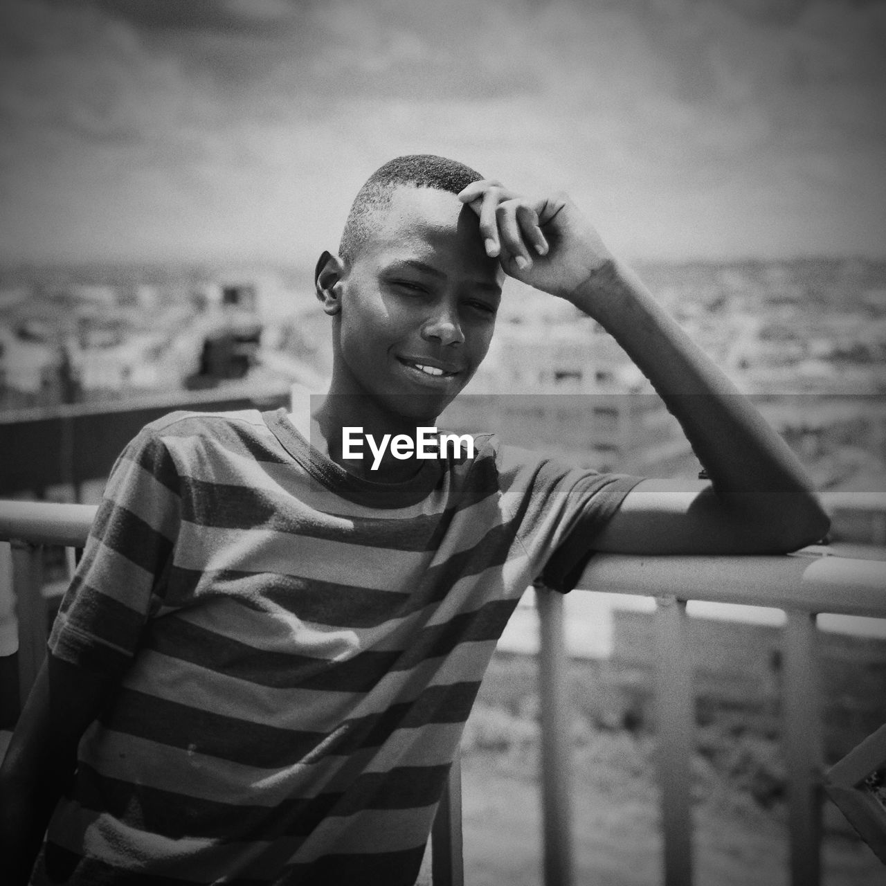 Portrait of teenage boy standing at railing