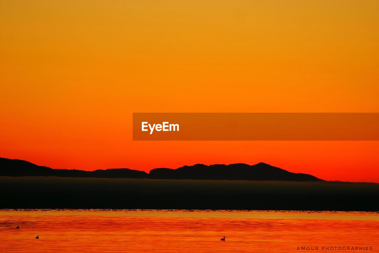 SCENIC VIEW OF SEA AGAINST ORANGE SKY DURING SUNSET