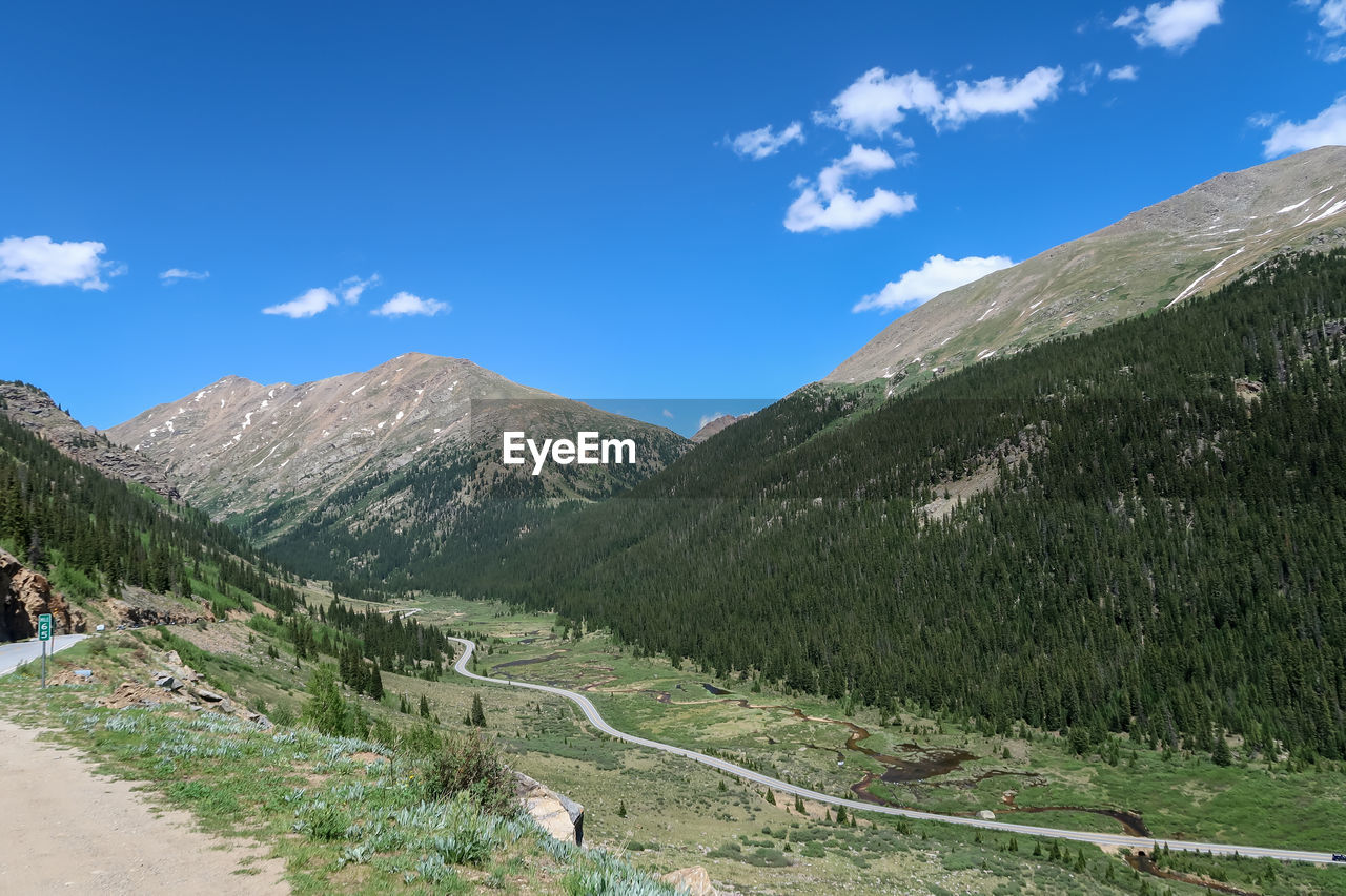 SCENIC VIEW OF MOUNTAIN ROAD AGAINST SKY