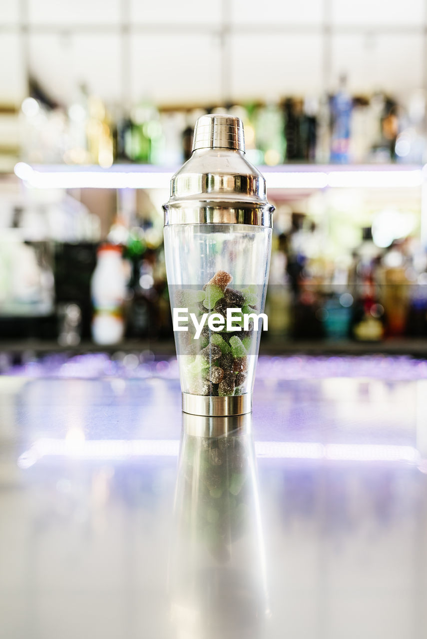 CLOSE-UP OF GLASS BOTTLE ON TABLE