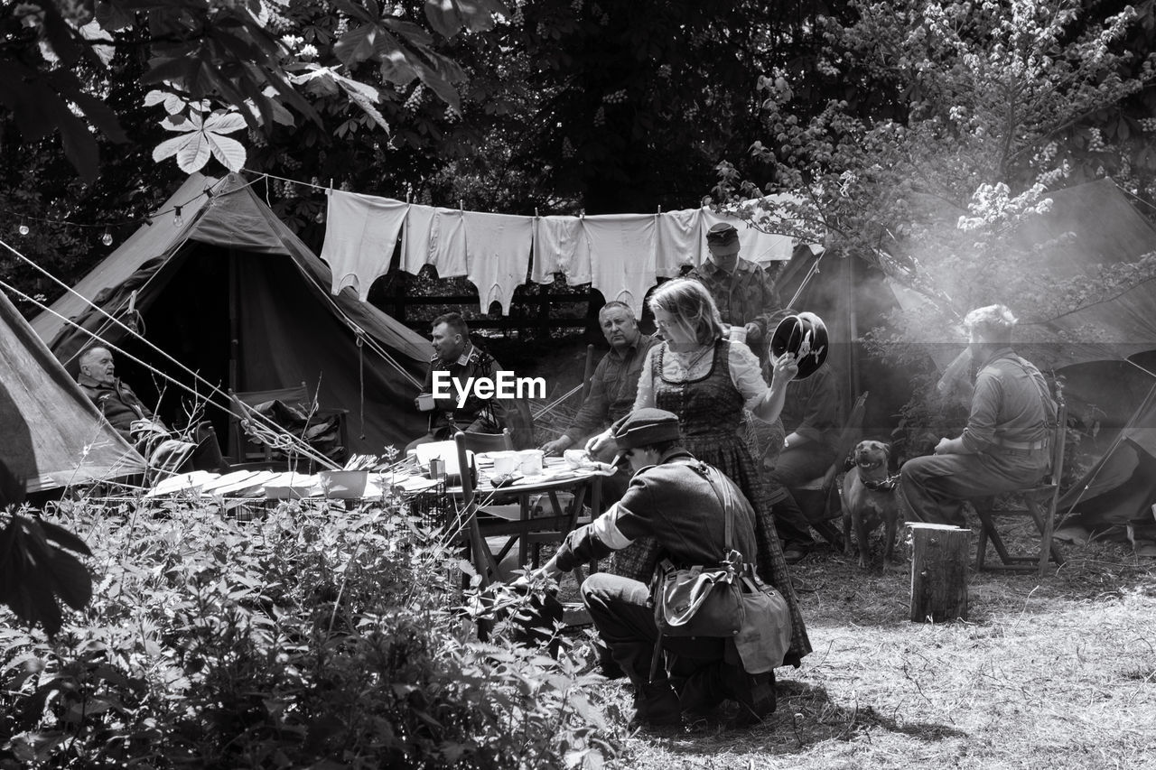 HIGH ANGLE VIEW OF PEOPLE SITTING ON TENT