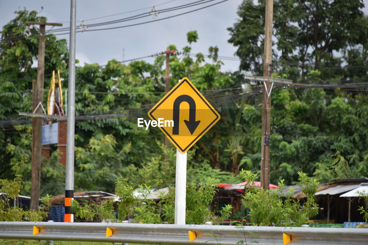 ROAD SIGN AGAINST TREES AND PLANTS