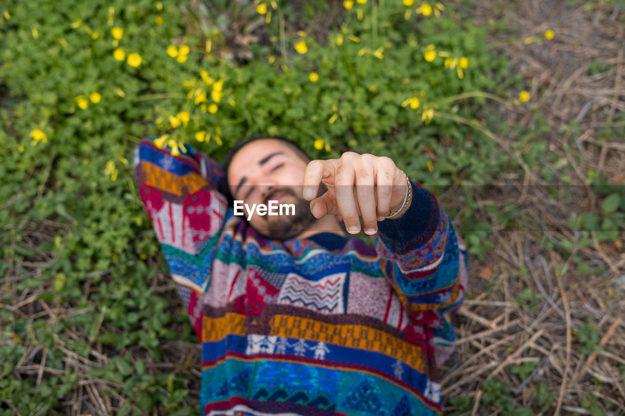 Moroccan man laying on the ground and holding his hand up to the camera
