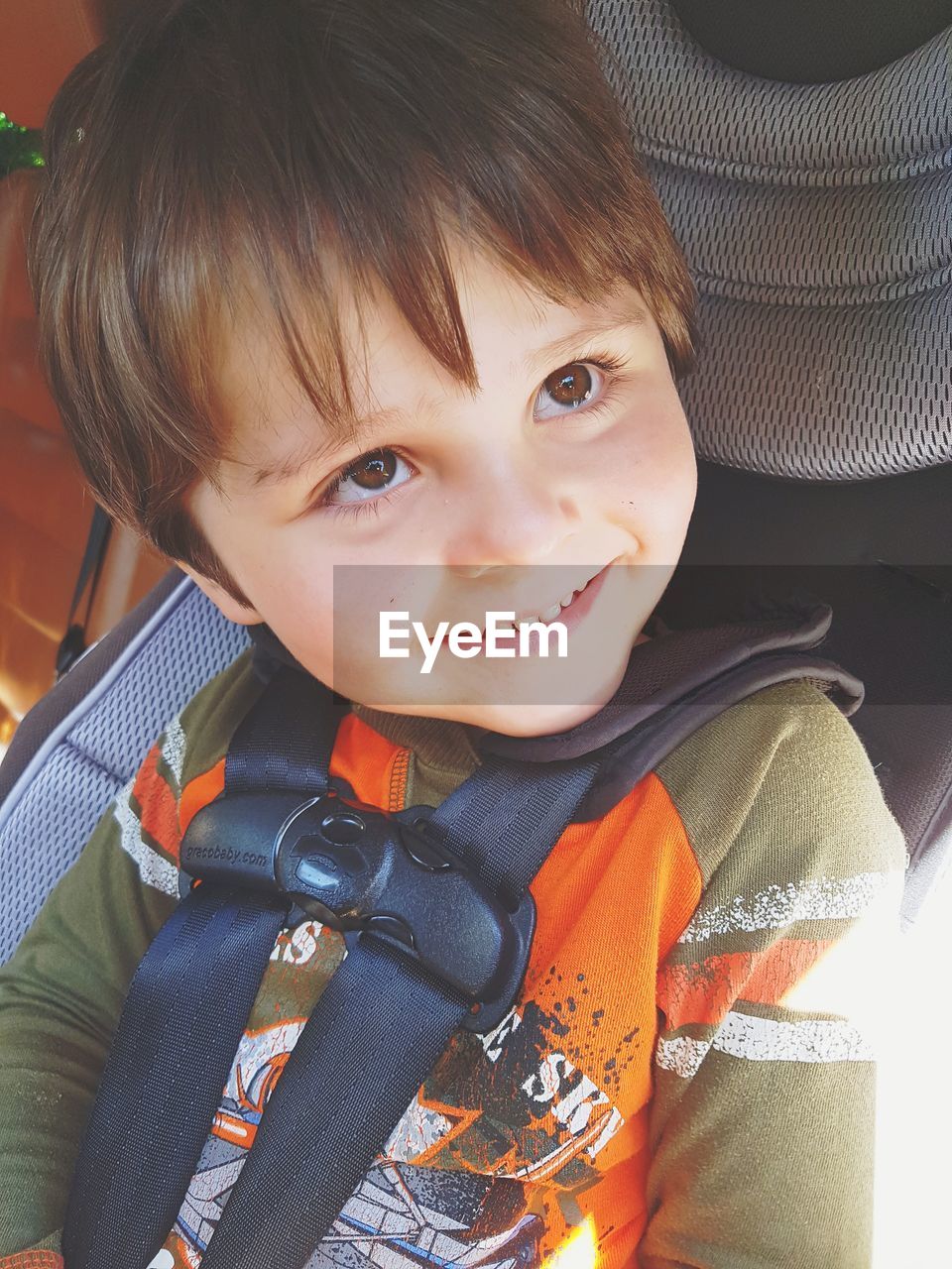 Smiling boy looking away while sitting in car