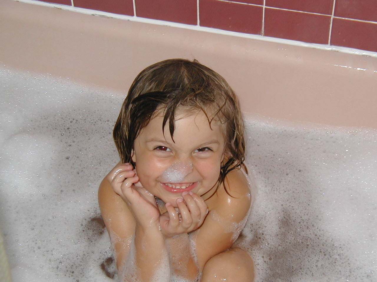Portrait of playful girl having bath in tub