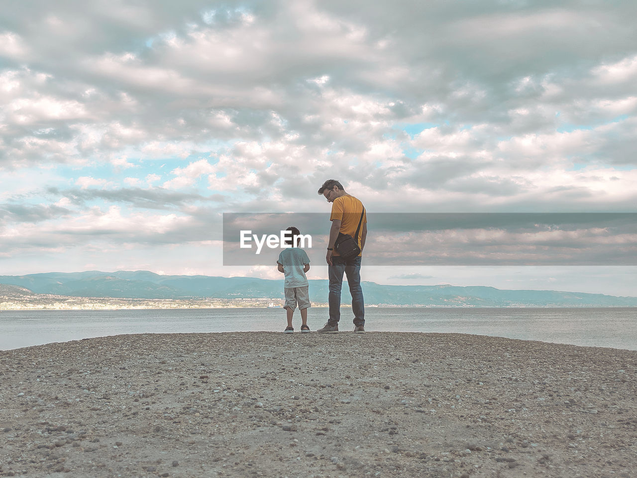 Full length of father and son at standing at beach