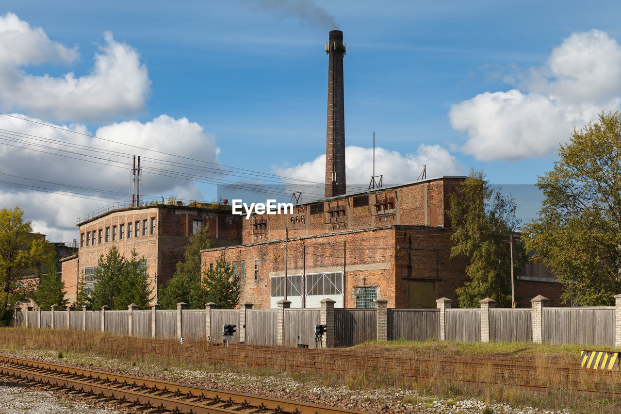 VIEW OF FACTORY AGAINST CLOUDY SKY