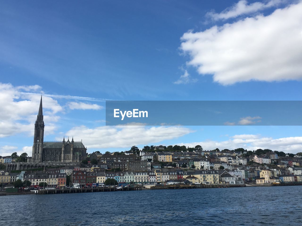 Buildings at waterfront against cloudy sky - cobh, ireland