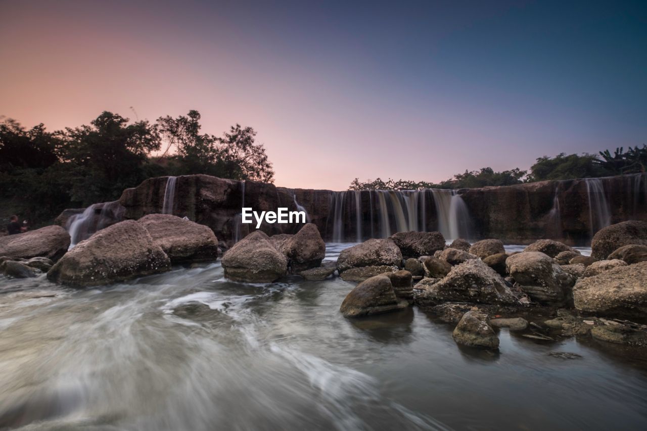 SCENIC VIEW OF WATERFALL AGAINST CLEAR SKY