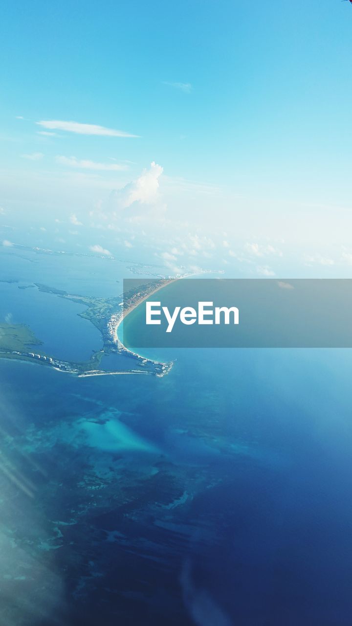 Aerial view of sea against blue sky