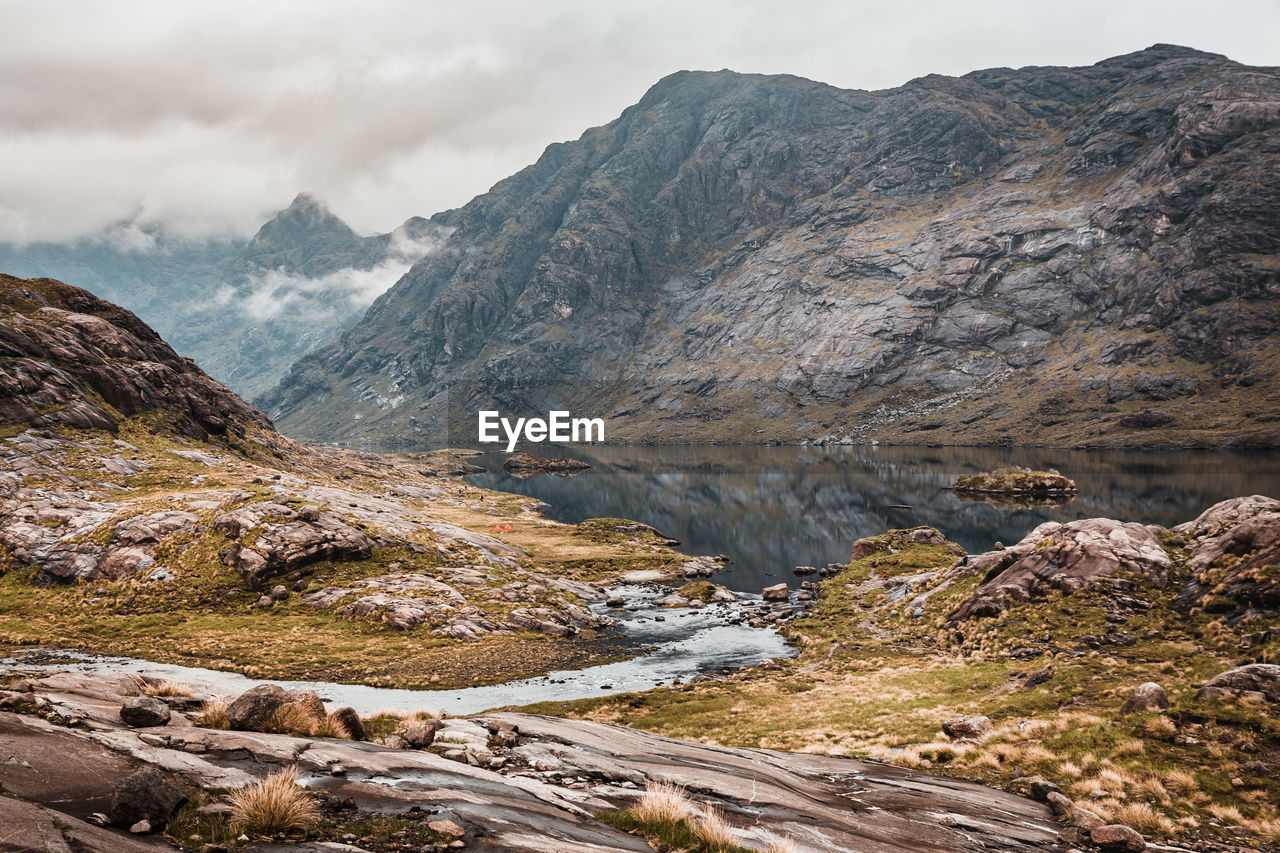 Scenic view of sea and mountain against sky