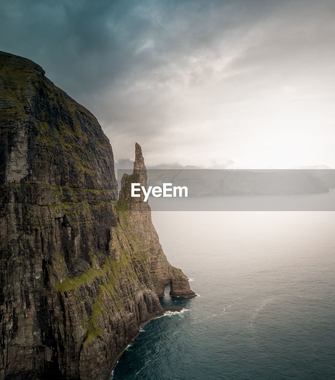 Scenic view of sea by mountains against sky