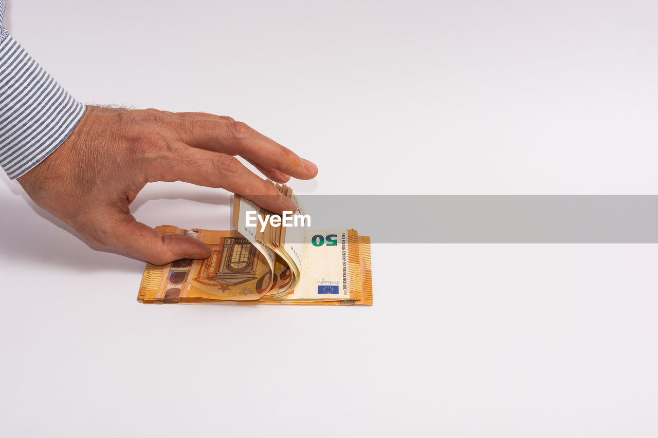 CLOSE-UP OF A HAND HOLDING PAPER