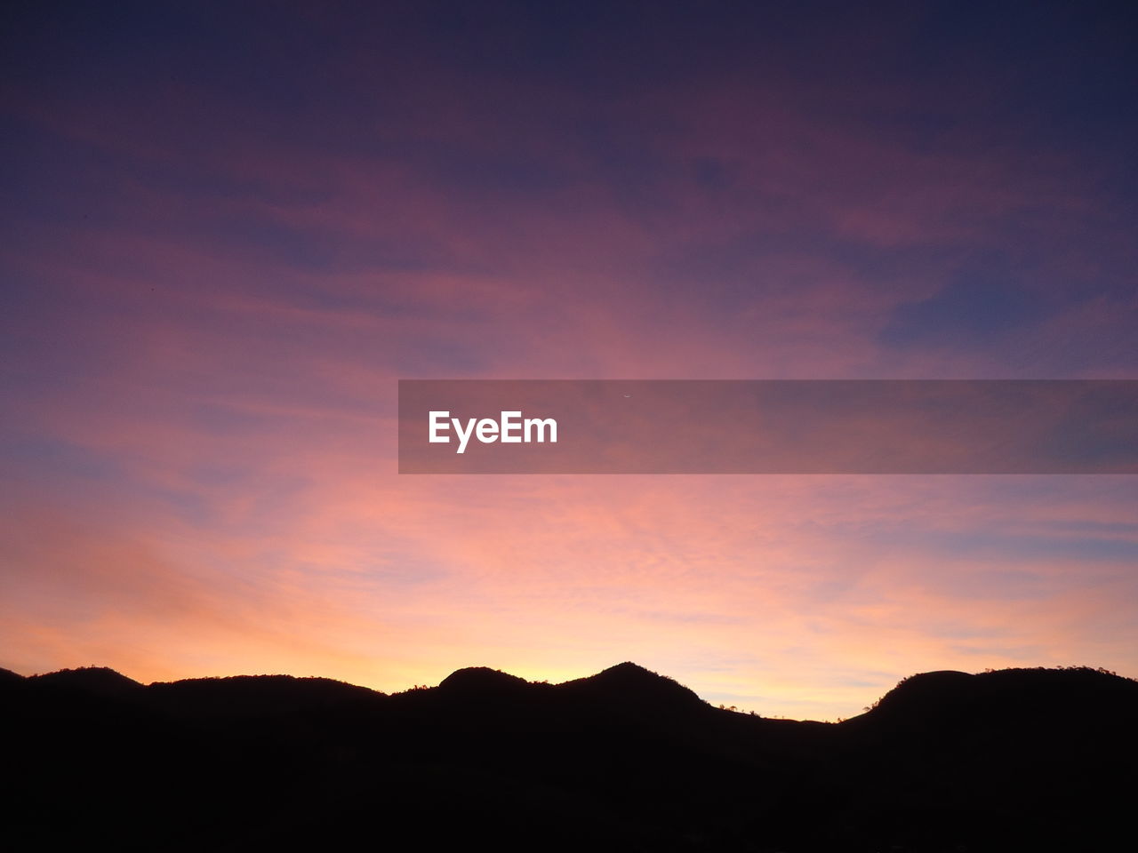 Silhouette mountains against sky at dusk