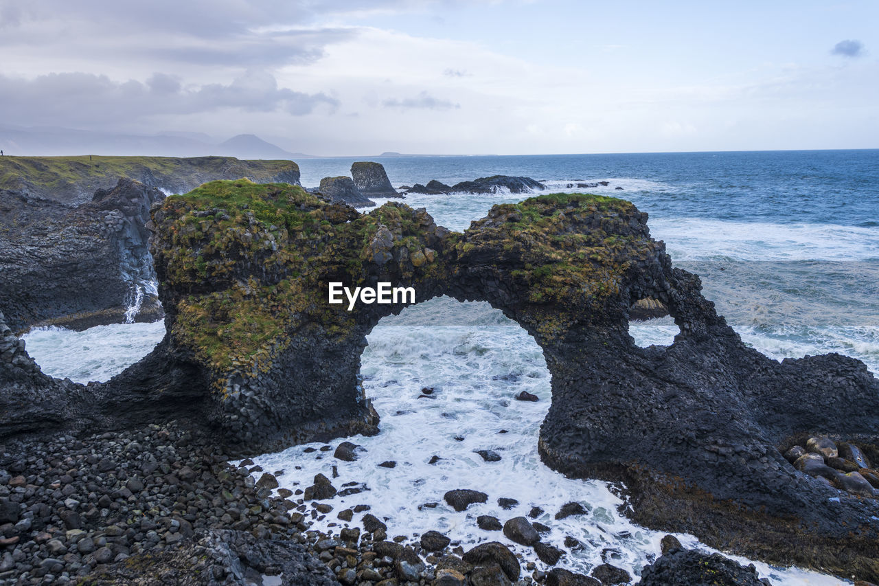 SCENIC VIEW OF ROCK FORMATION ON BEACH AGAINST SKY