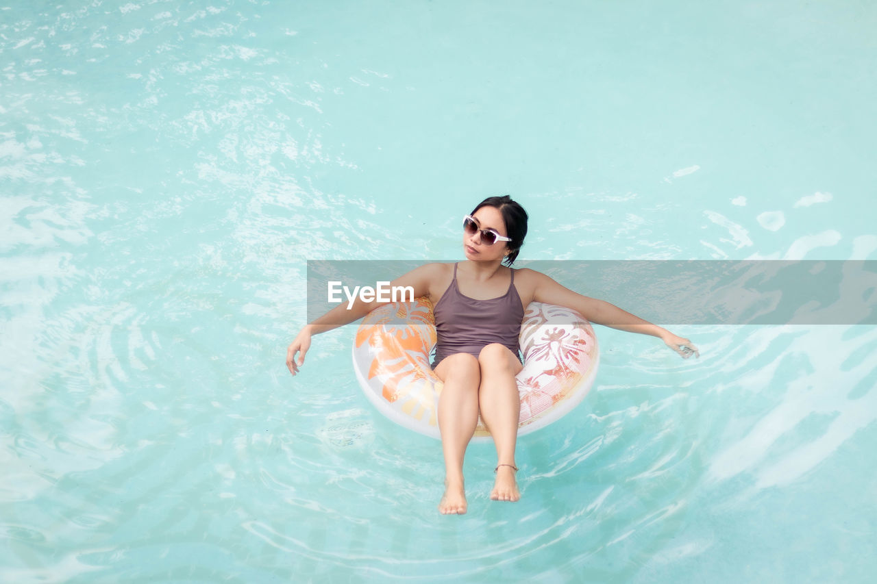 High angle view of woman in inflatable ring on pool