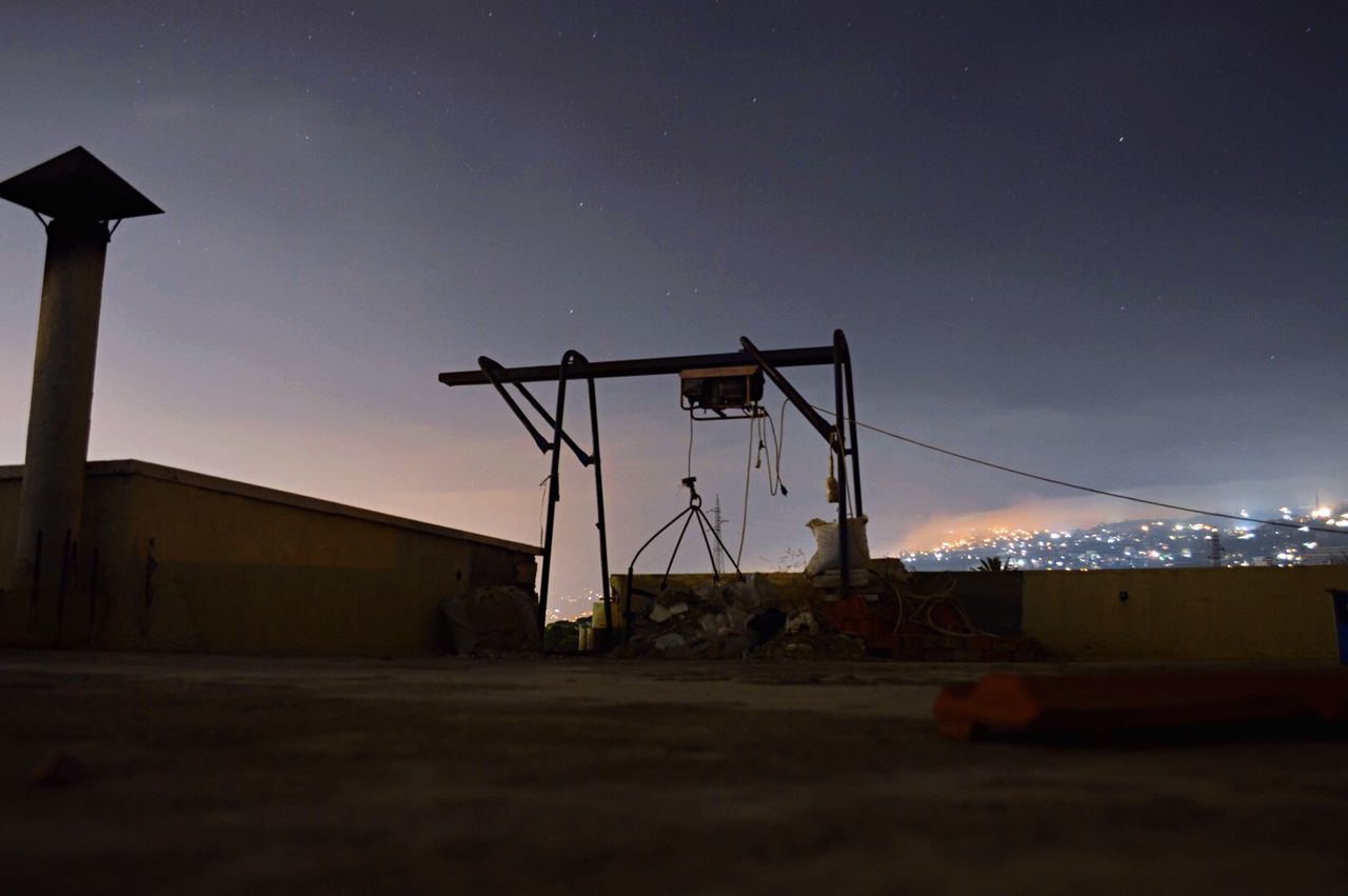 Low angle view of equipment on building terrace against cloudy sky