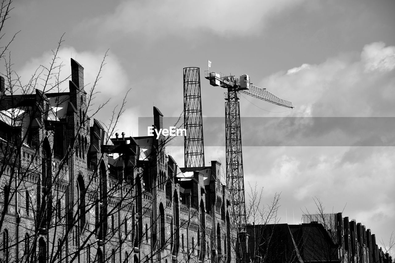 sky, architecture, cloud, black and white, built structure, urban area, monochrome, nature, monochrome photography, industry, building exterior, no people, construction industry, outdoors, low angle view, construction site, electricity, day, machinery, tree, building, development, crane - construction machinery, business finance and industry, cityscape