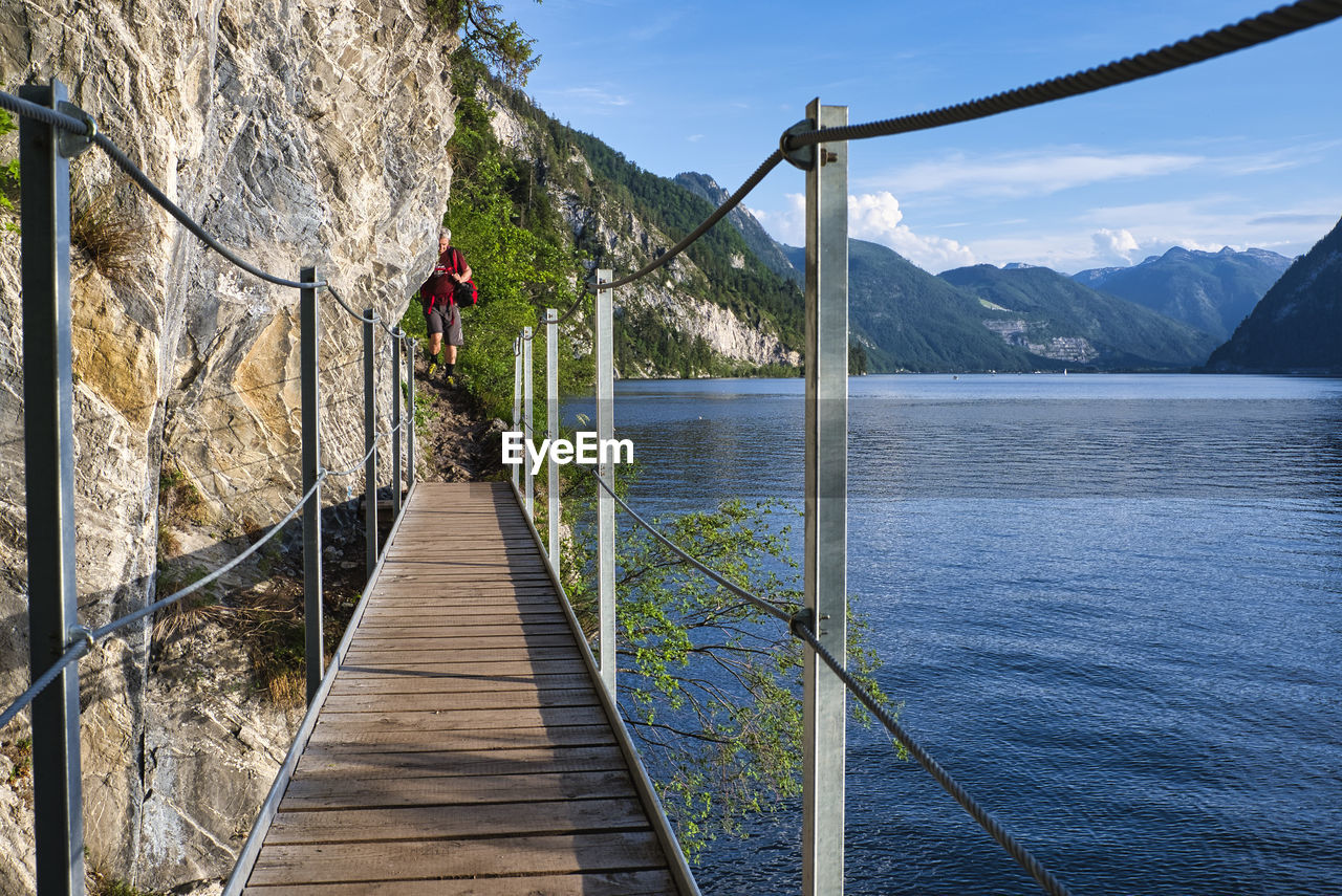 BOARDWALK BY LAKE AGAINST SKY