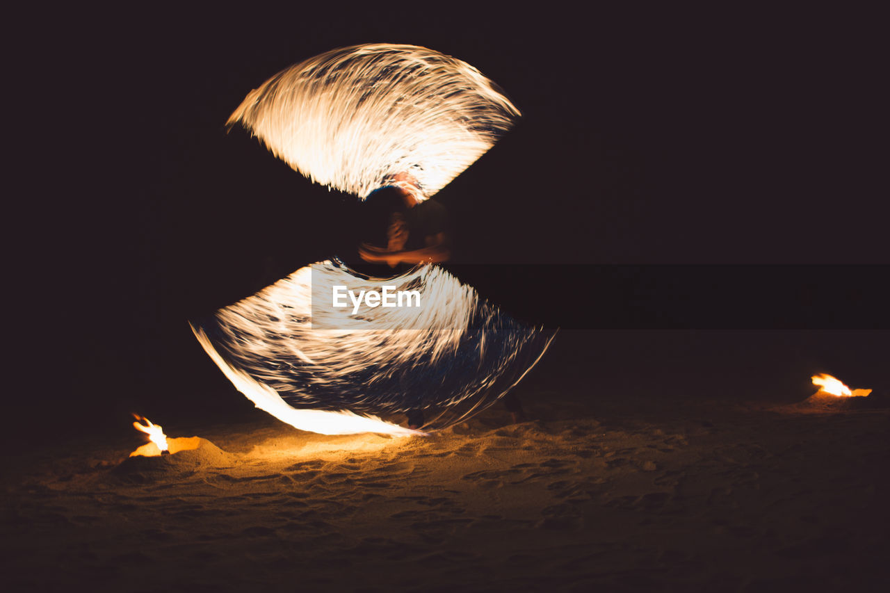 CLOSE-UP OF BONFIRE AGAINST ILLUMINATED STAR SHAPE