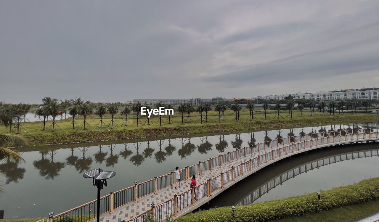 water, architecture, built structure, river, sky, nature, bridge, travel destinations, travel, tourism, waterway, environment, group of people, cloud, outdoors, city, plant, large group of people, transportation, reflection, sports, reservoir, landscape, sport venue, day