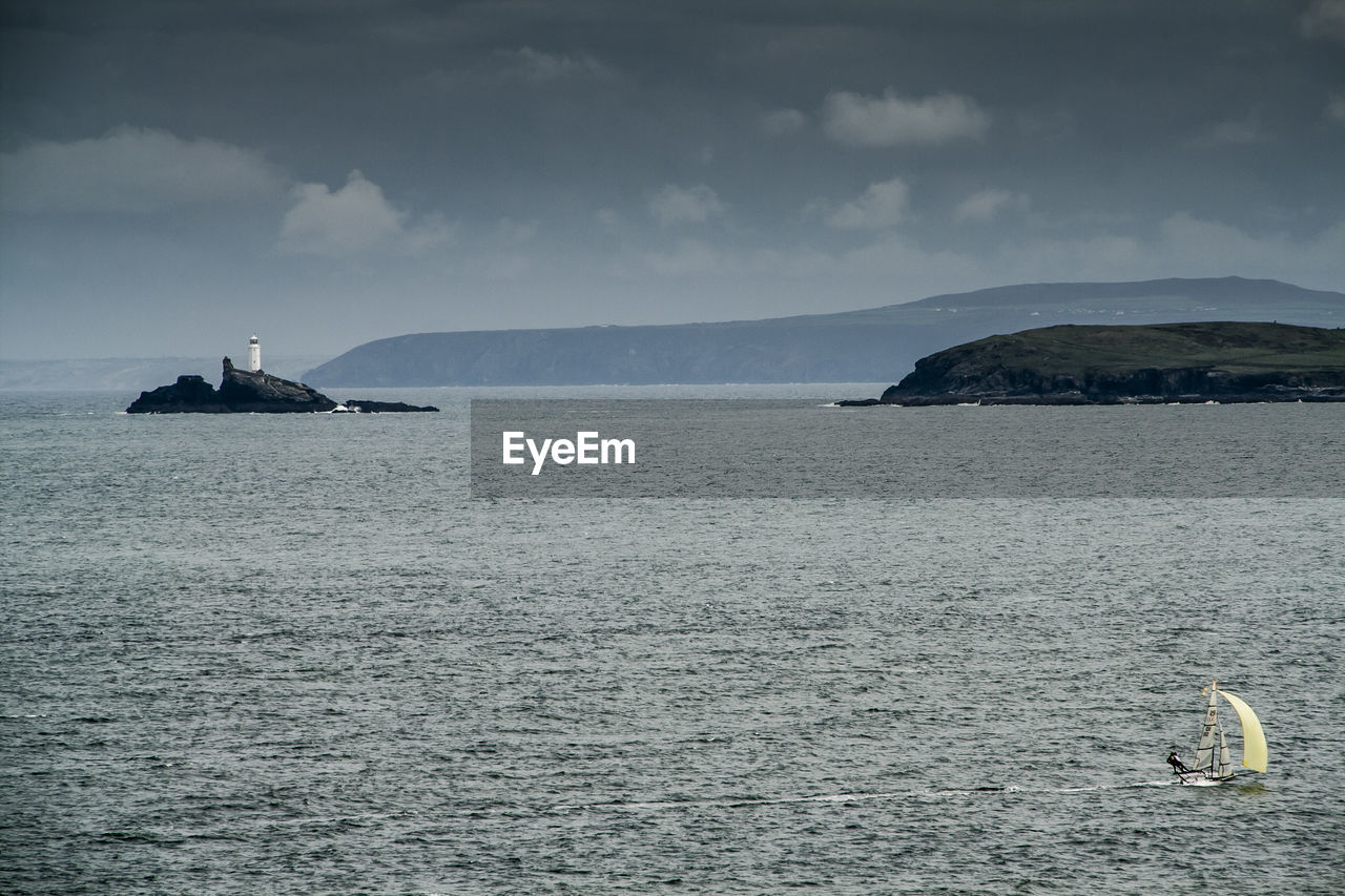 Scenic view of sea and mountains against sky