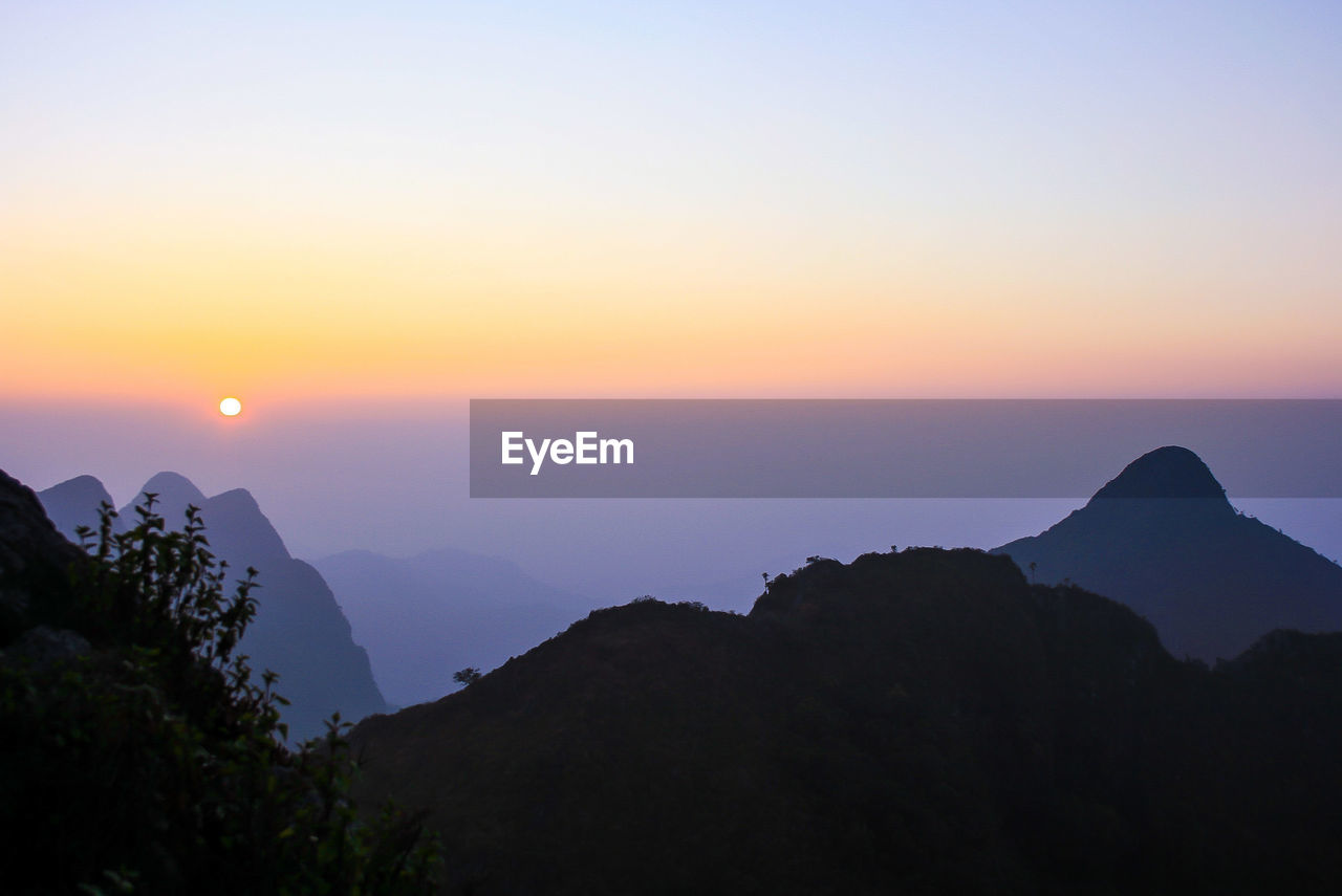 Scenic view of silhouette mountains against sky during sunset