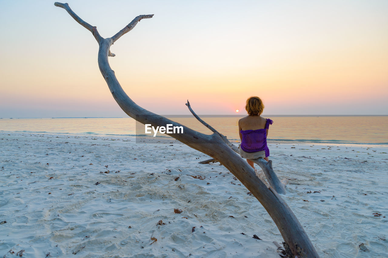 REAR VIEW OF WOMAN ON BEACH