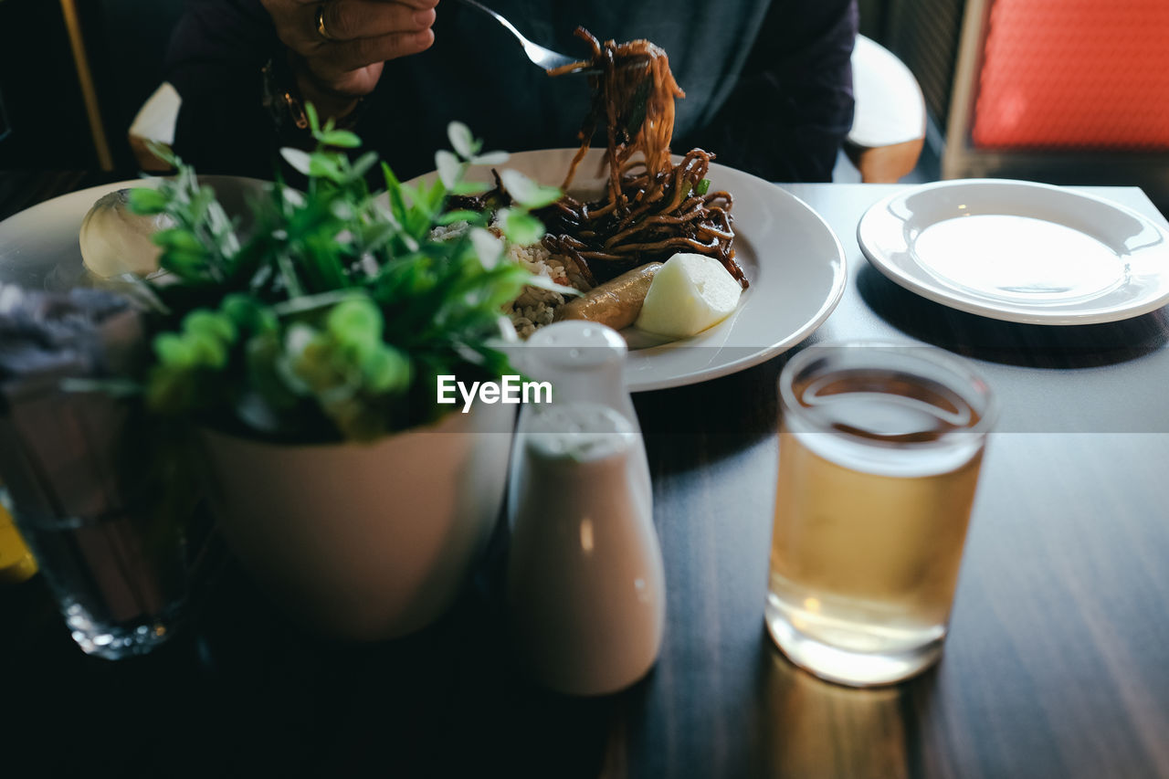 Midsection of person having breakfast in a restaurant