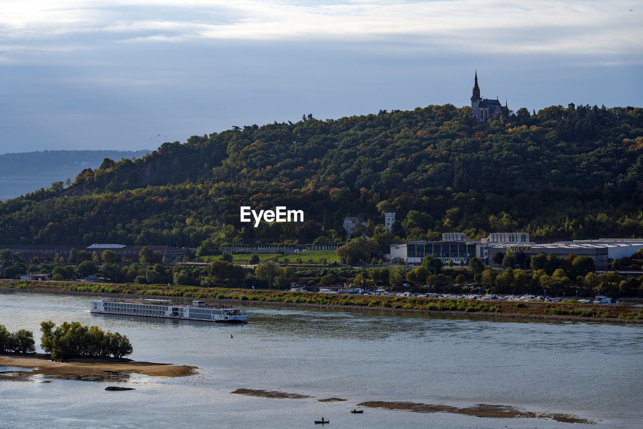 Scenic view of river by buildings against sky