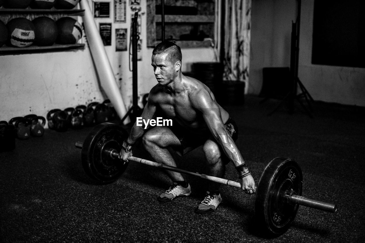 Portrait of man lifting barbell in gym