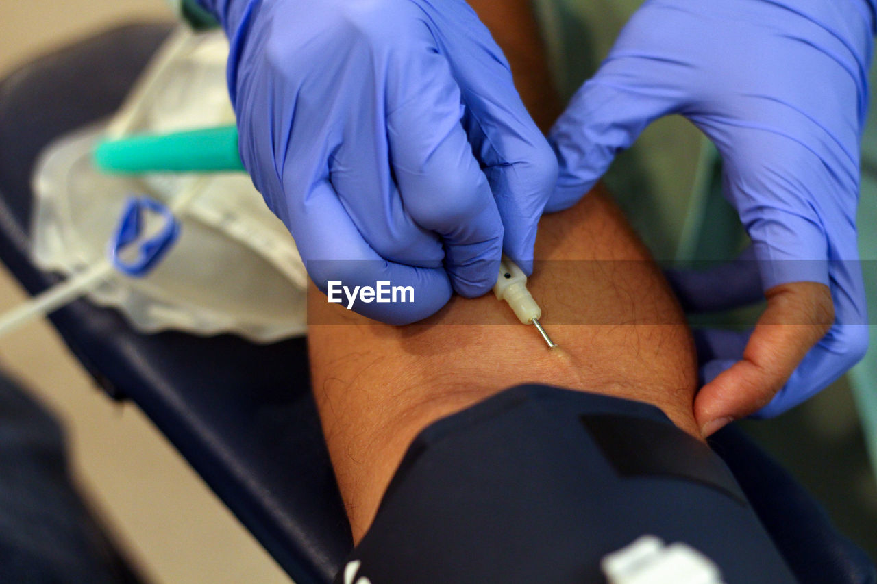 Cropped image of doctor preparing patient for blood donation