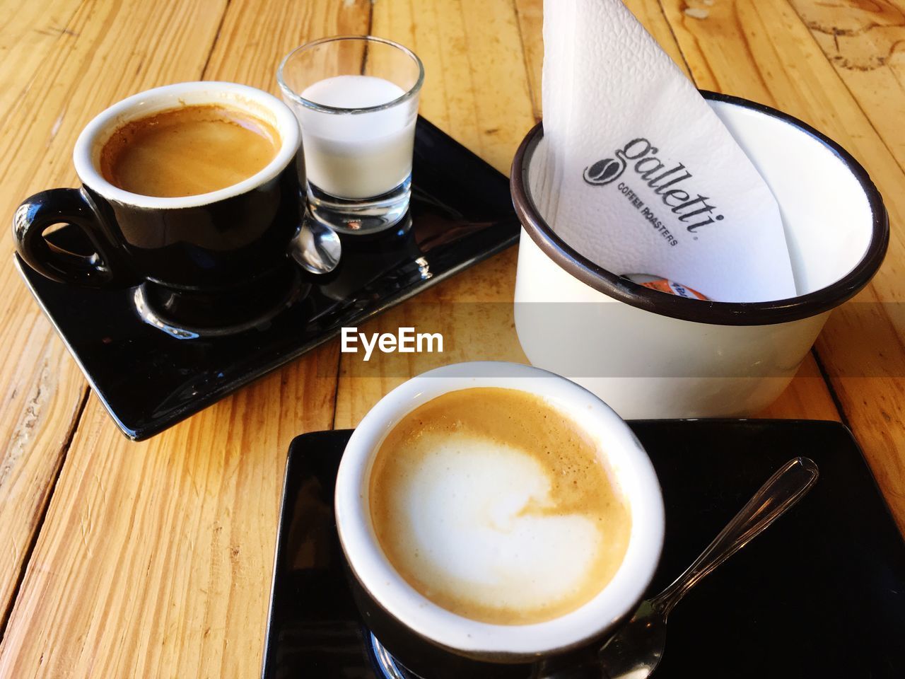 HIGH ANGLE VIEW OF CAPPUCCINO AND COFFEE CUP ON TABLE