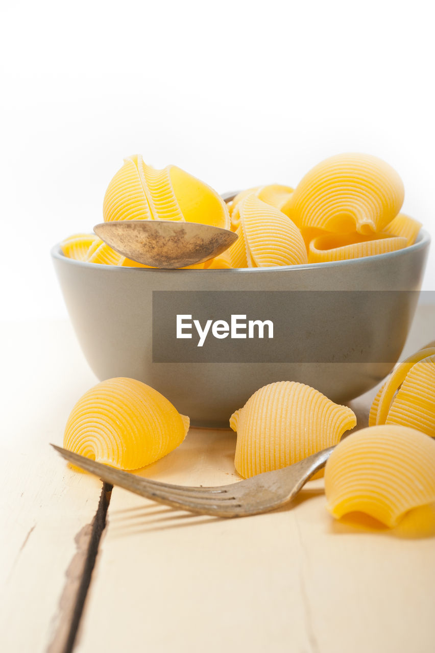 Conchiglies in bowl on table