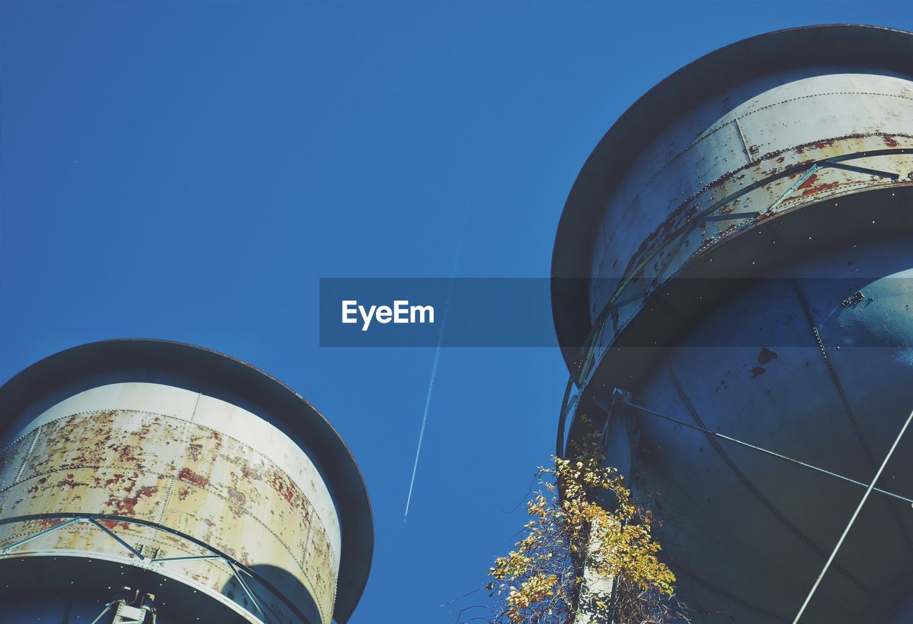 Low angle view of water towers against blue sky at caumsett state historic park