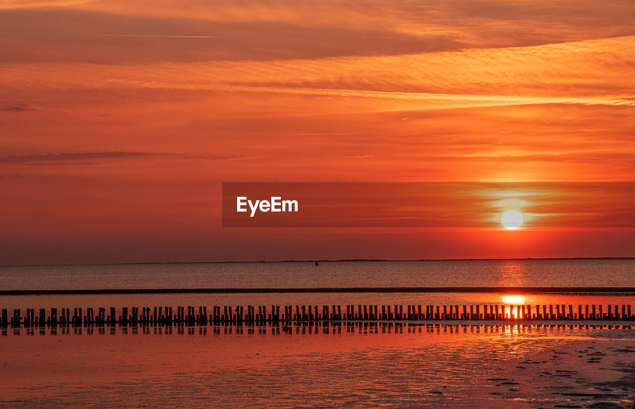 Scenic view of sea against orange sky