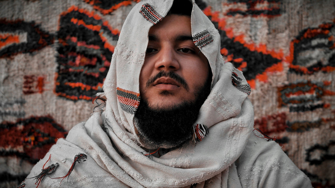 Portrait of young man covered in blanket