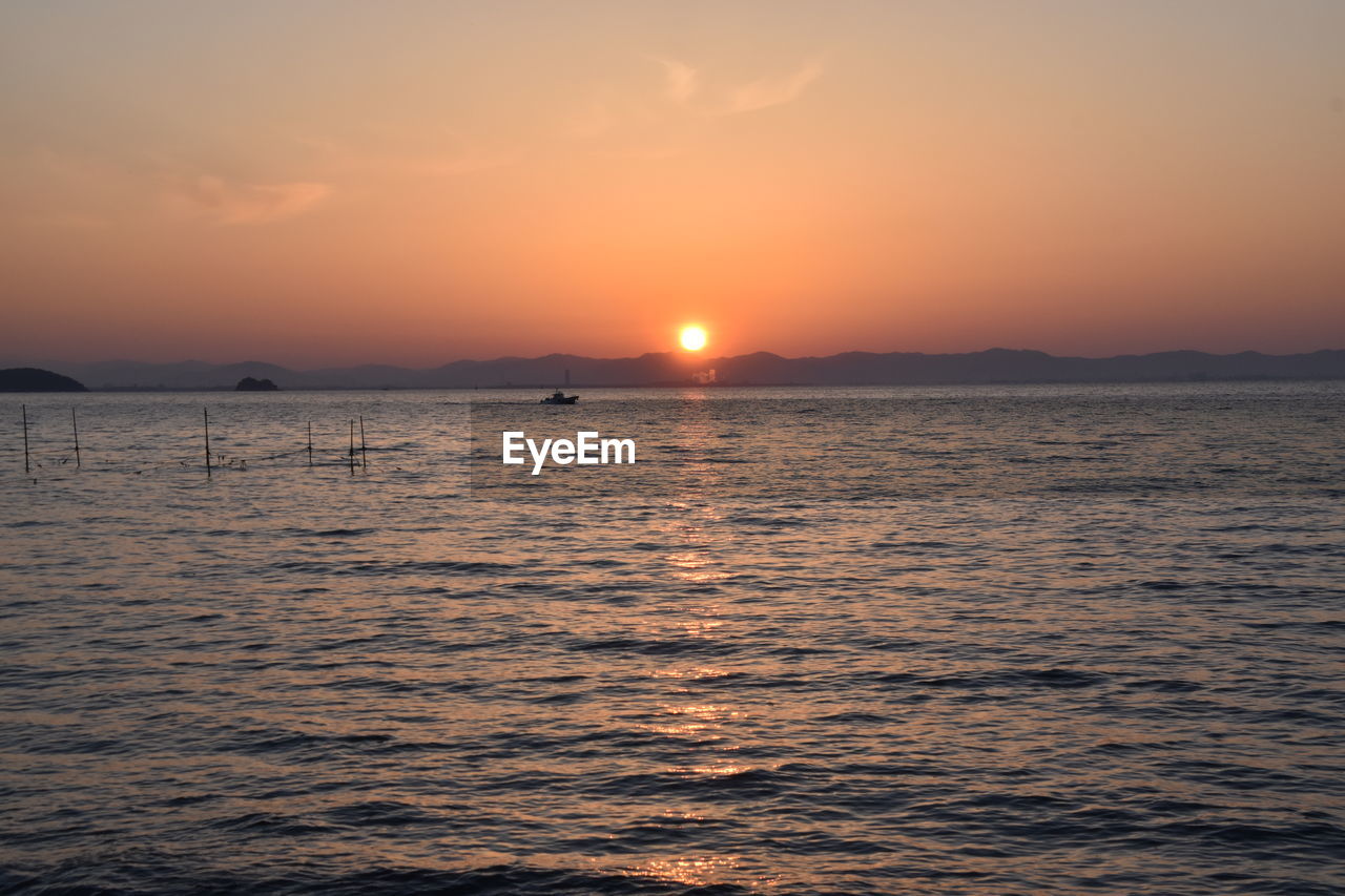 SCENIC VIEW OF SEA AGAINST ORANGE SKY DURING SUNSET