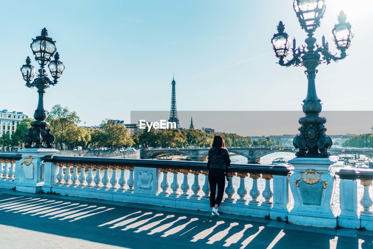 Full length of woman standing on bridge against clear sky