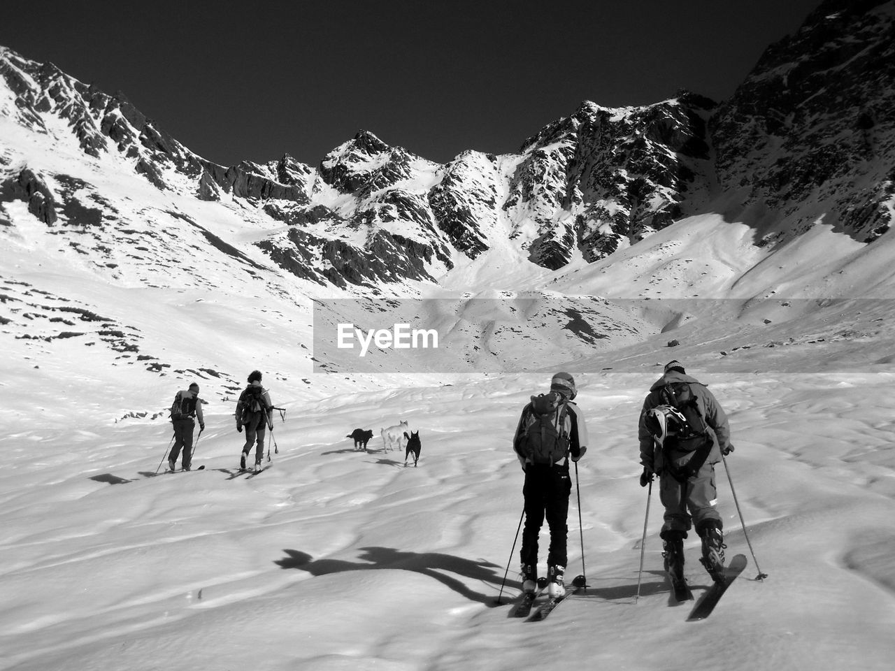 PEOPLE SKIING ON SNOWCAPPED MOUNTAINS