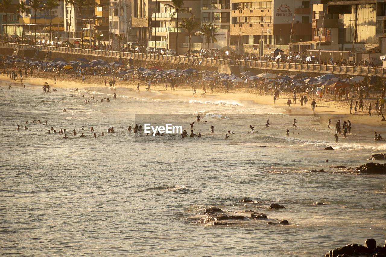  people are seen during strong sun on praia da barra in the city of salvador, bahia.