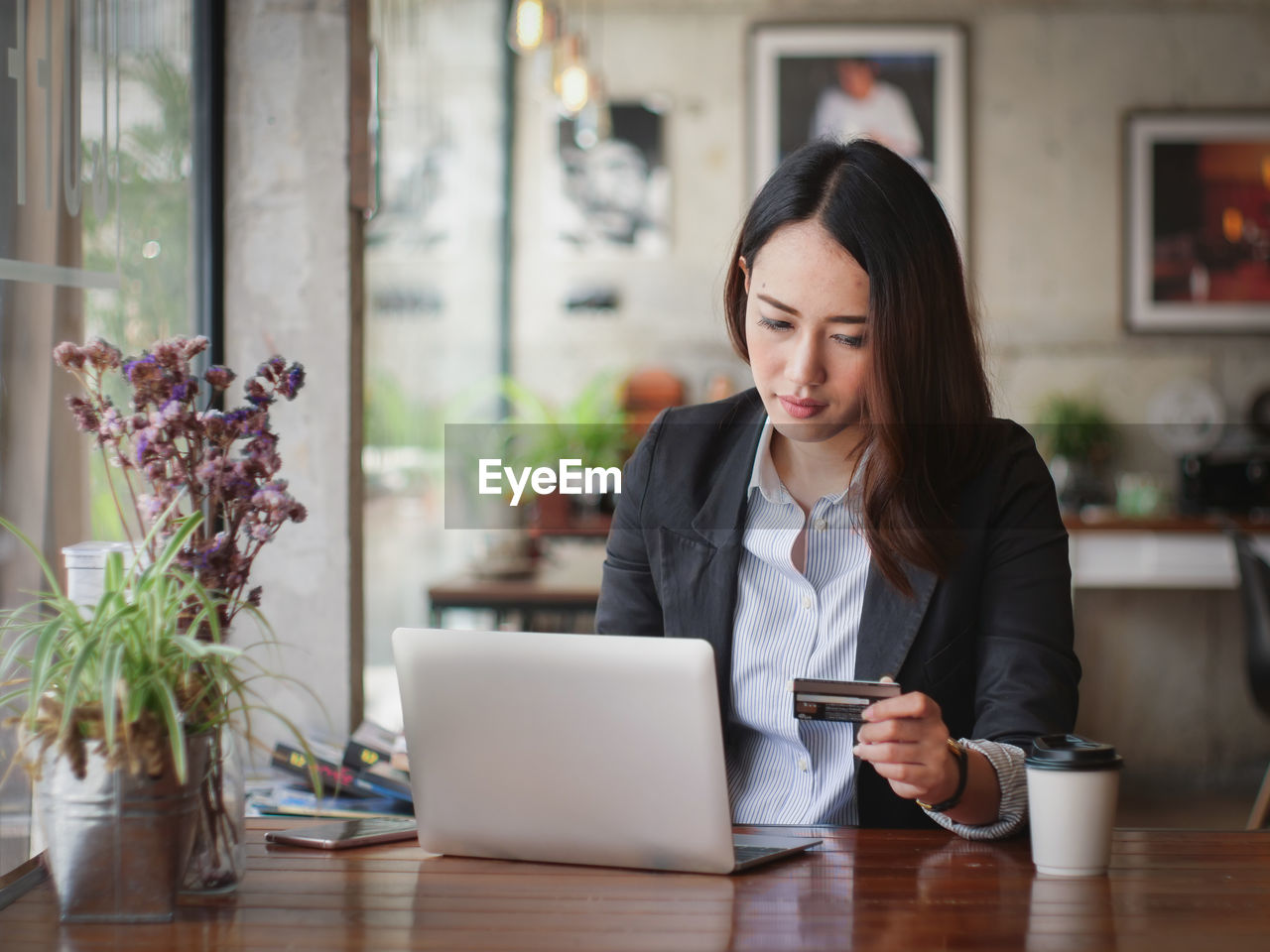 Businesswoman online shopping in cafe