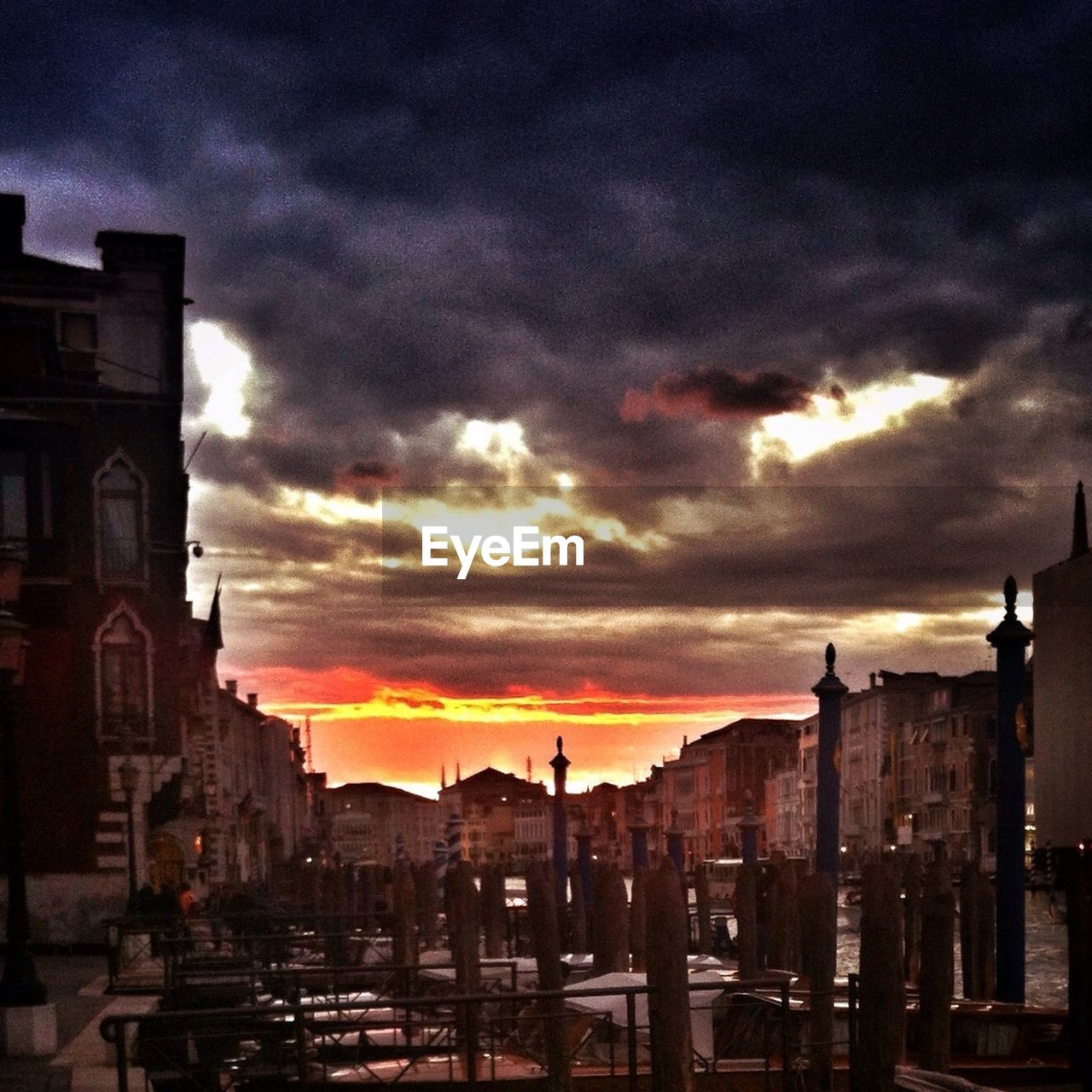 VIEW OF BUILDINGS AGAINST CLOUDY SKY AT SUNSET