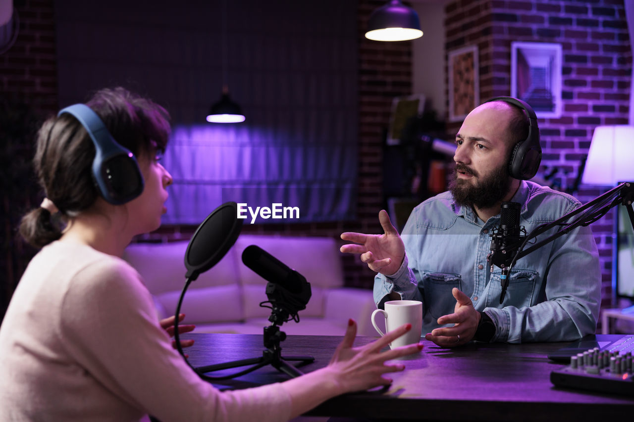 Man and woman podcasting at studio